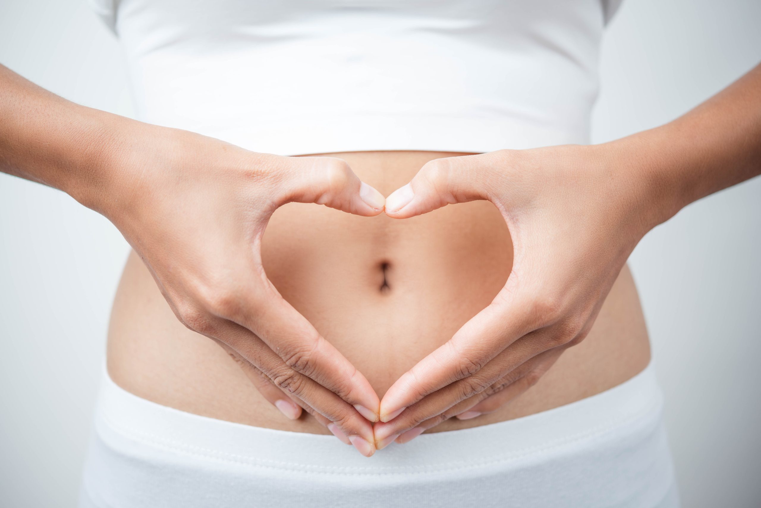 Close,Up,Of,Woman's,Hands,Made,Heart,On,Belly,Isolated