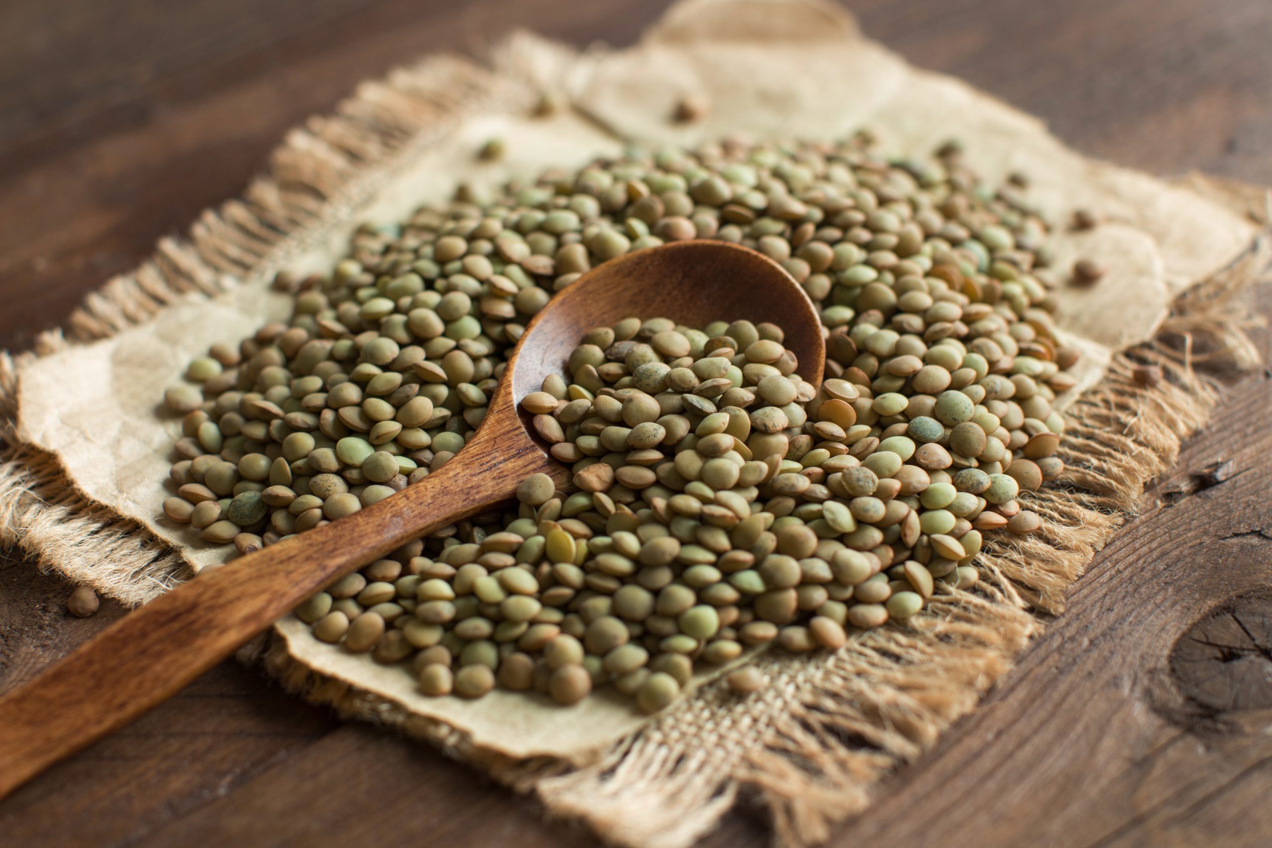 Green,Lentils,With,A,Spoon,On,A,Wooden,Table,Top