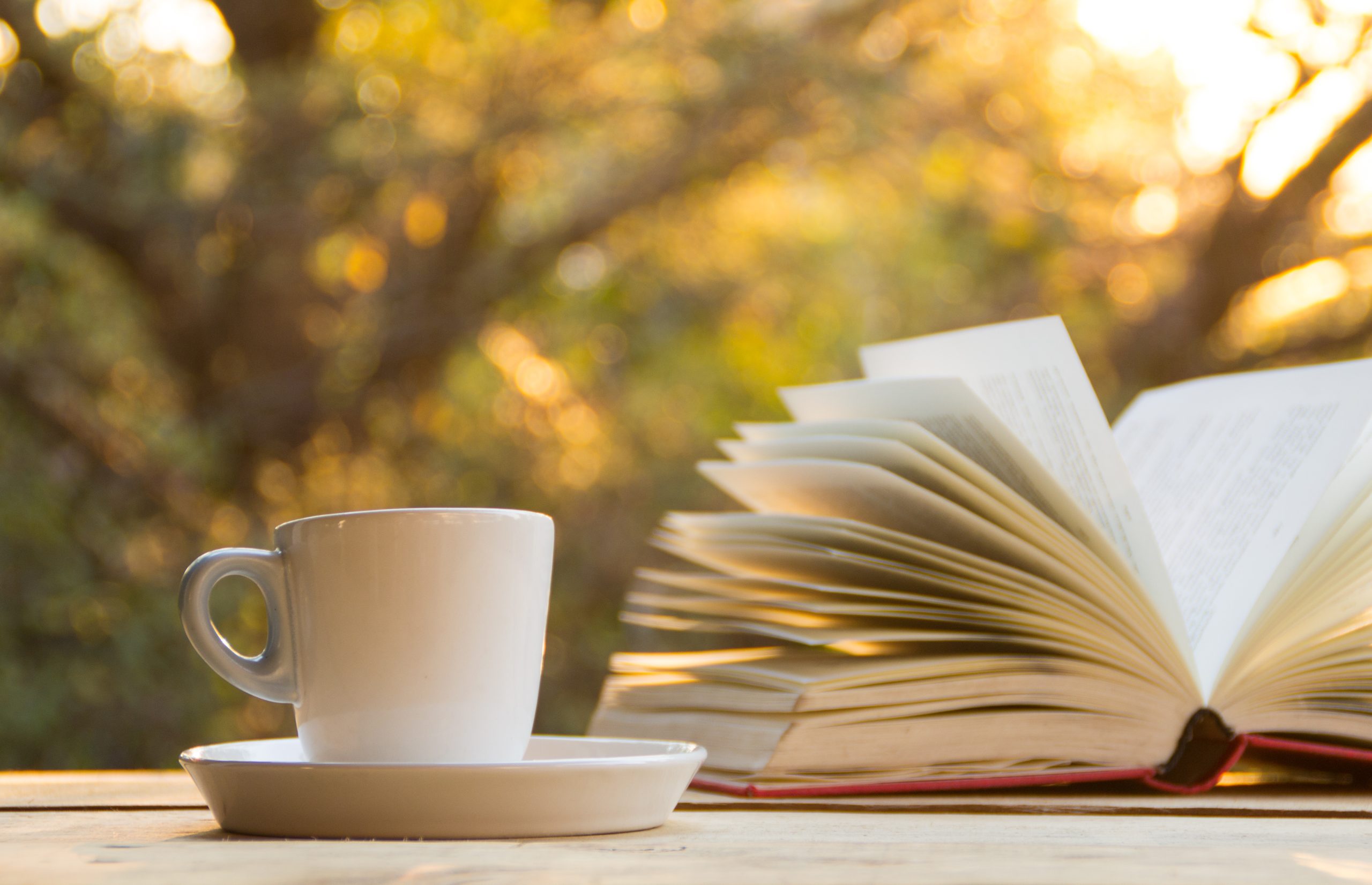 A,Cup,Of,Coffee,And,Book,On,The,Wooden,Table